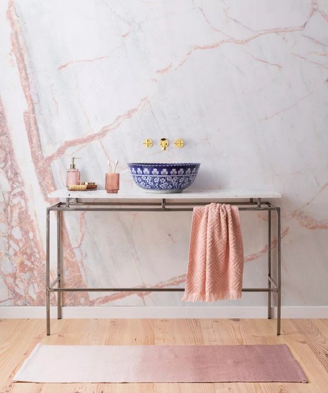 Декоративний умивальник у невеликій ванній кімнаті зі стіною під мармур у пилово-рожевому кольорі